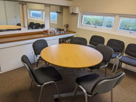 Small meeting room withe a round table and chairs around it.