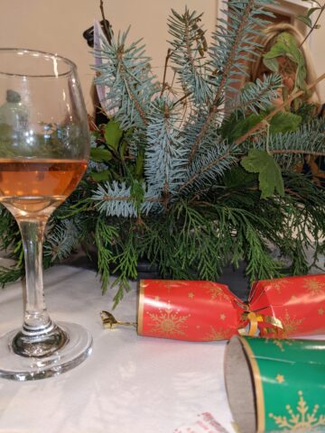 Glass of wine, Christmas cracker and festive table decoration