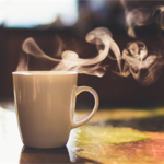 White mug with steam coming from it on a table